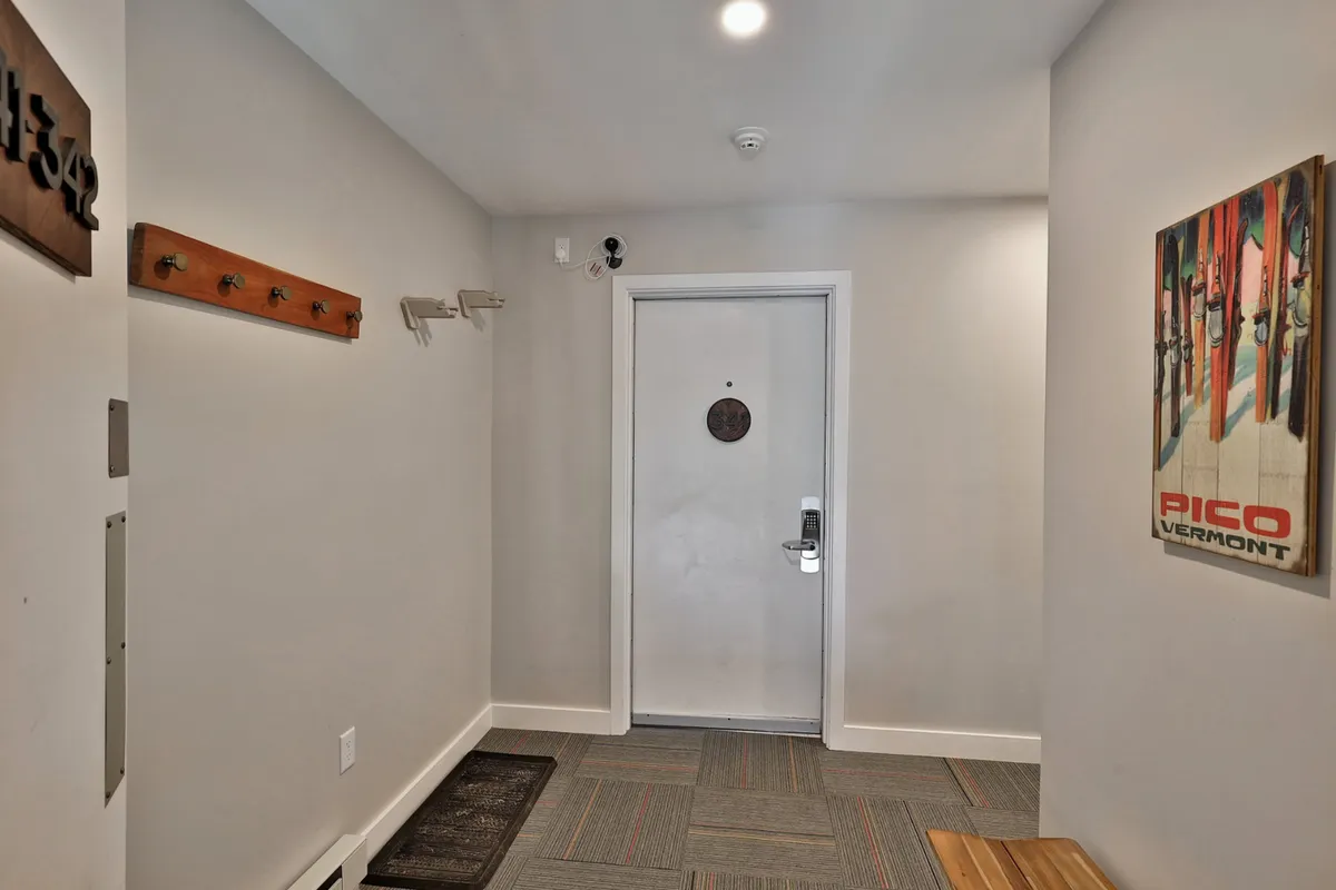 This image captures the welcoming front door of the studio, complete with wall art and practical coat hooks. It suggests a sense of arrival and hints at the ease of access through features like smart locks and contactless check-in, setting the tone for a private yet hotel-like experience.